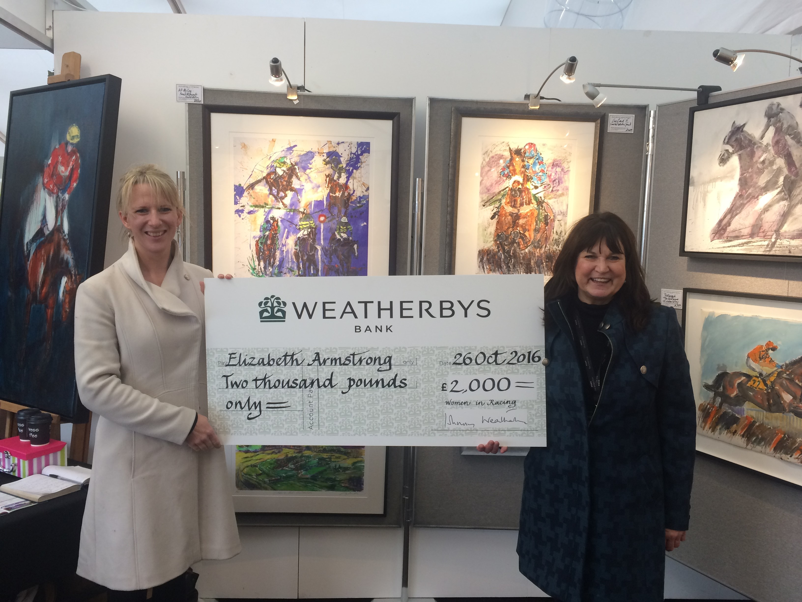 WiR committee member Naomi Mellor (left) presents Elizabeth Armstrong with a £2000 bursary award at Cheltenham Racecourse.